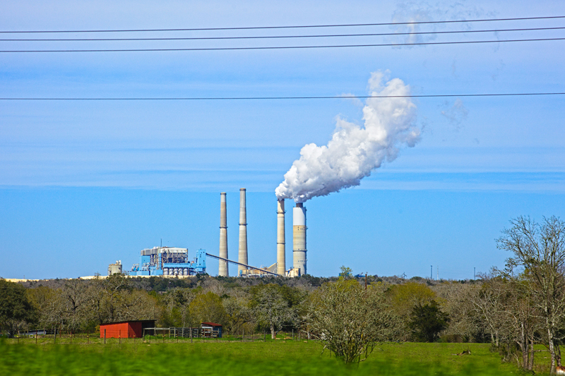 A coal plant with with steam billowing from stacks