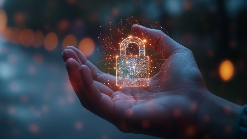 A hand holding a glowing digital padlock symbol, representing cybersecurity and data protection. The background is blurred with soft lights, creating a futuristic atmosphere.