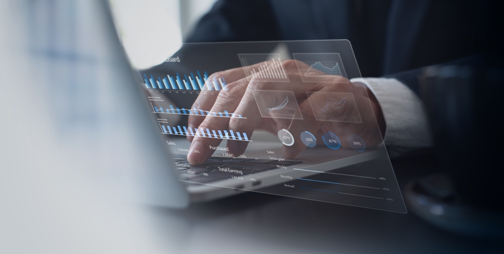 A composite photo of a businessman analyzing data on a laptop
