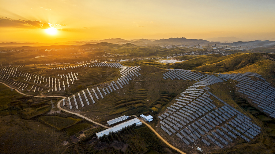 Industrial aerial sunrise mountain solar photovoltaic power plant